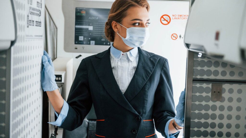 Flight attendant wearing mask in an airplane